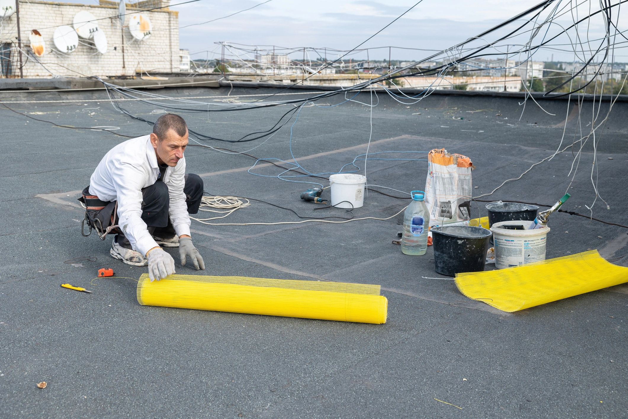 Roof technician performing inspection and repair preparation